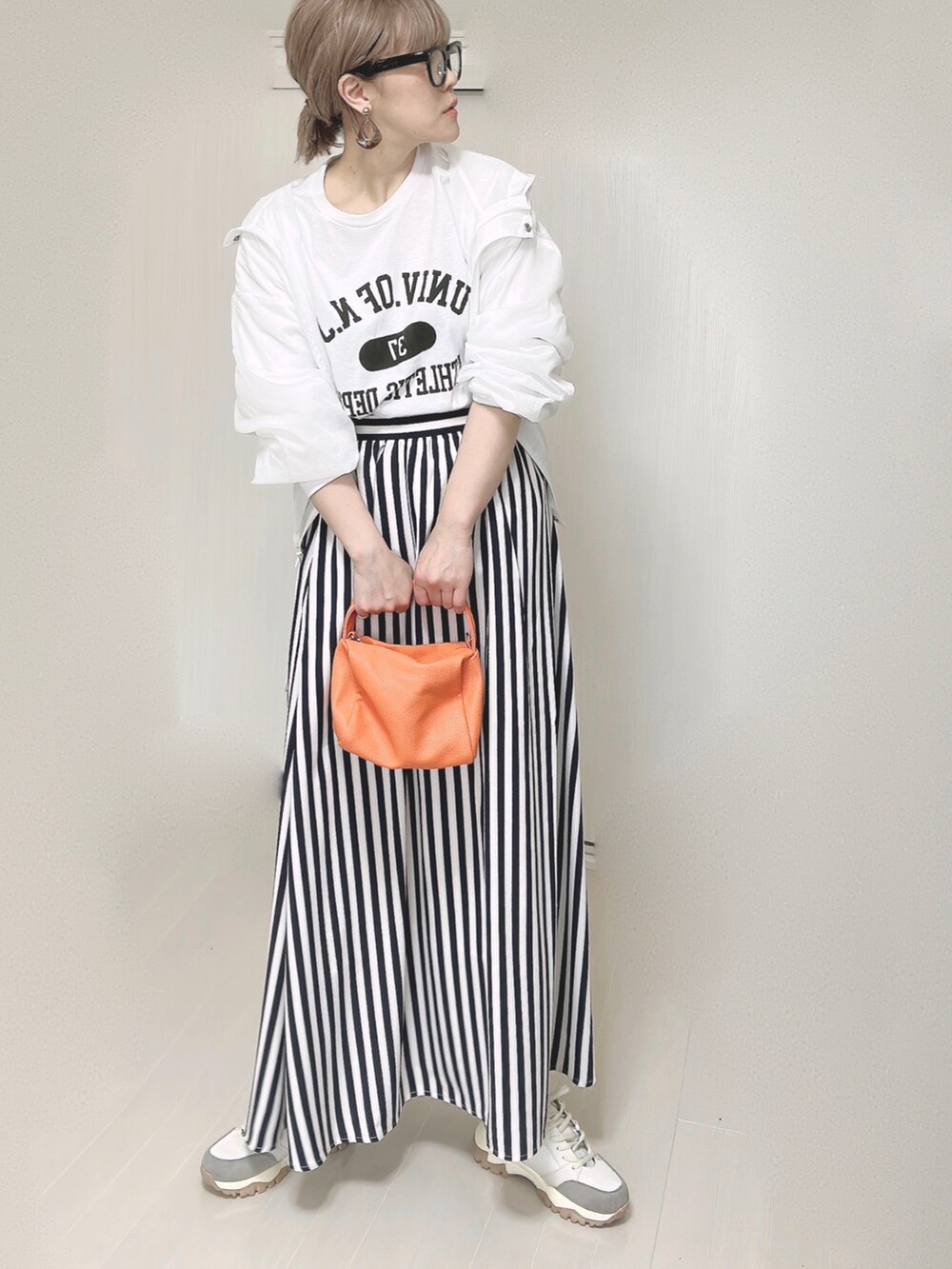 ホワイト系のTシャツ/カットソー、オレンジ系のショルダーバッグ、ブルー系のスカートを着用したレディースの春コーディネートの4枚目の写真