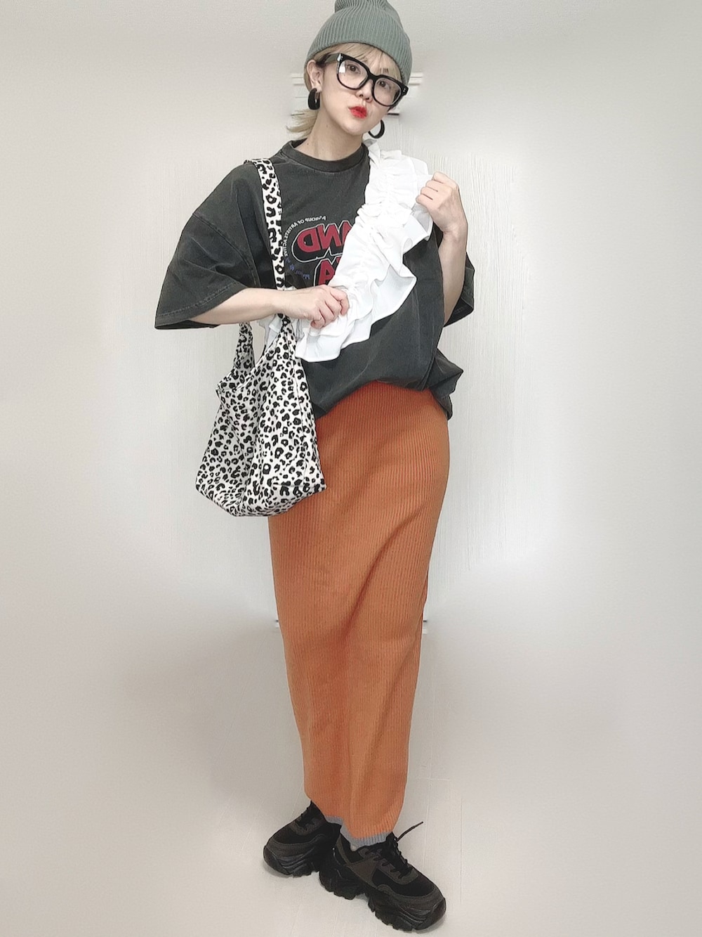ホワイト系のトートバッグ、グレー系のTシャツ/カットソー、オレンジ系のスカートを着用したレディースの夏コーディネートの2枚目の写真
