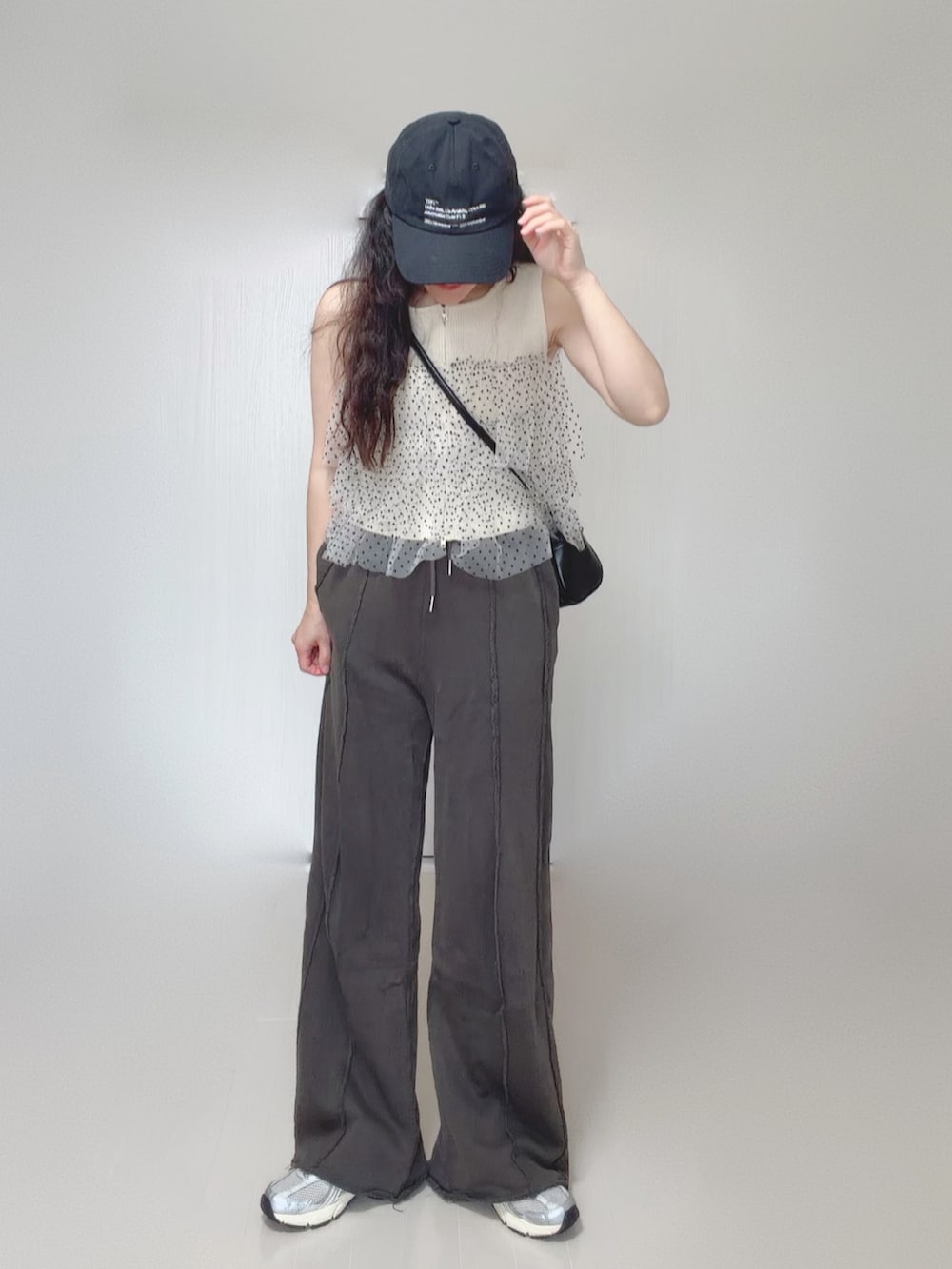 ホワイト系のニット/セーター、ブラック系のスウェットパンツ、ブラック系のボストンバッグを着用したレディースの夏コーディネートの2枚目の写真