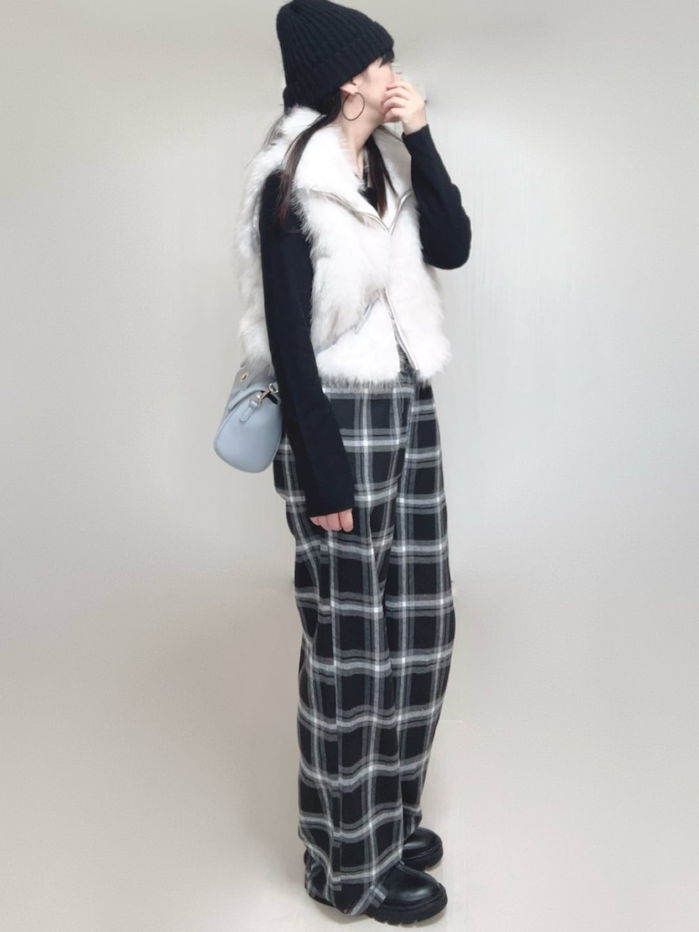 ホワイト系のベスト、ブラック系のTシャツ/カットソー、ブラック系のブーツを着用したレディースの秋コーディネートの5枚目の写真