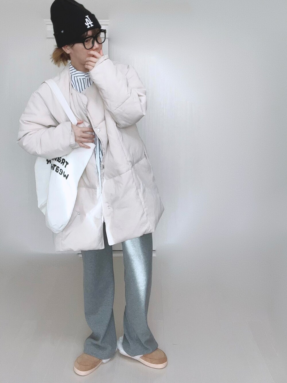 ホワイト系のダウンジャケット/コート、ホワイト系のシャツ/ブラウス、ホワイト系のトートバッグを着用したレディースの冬コーディネートの2枚目の写真