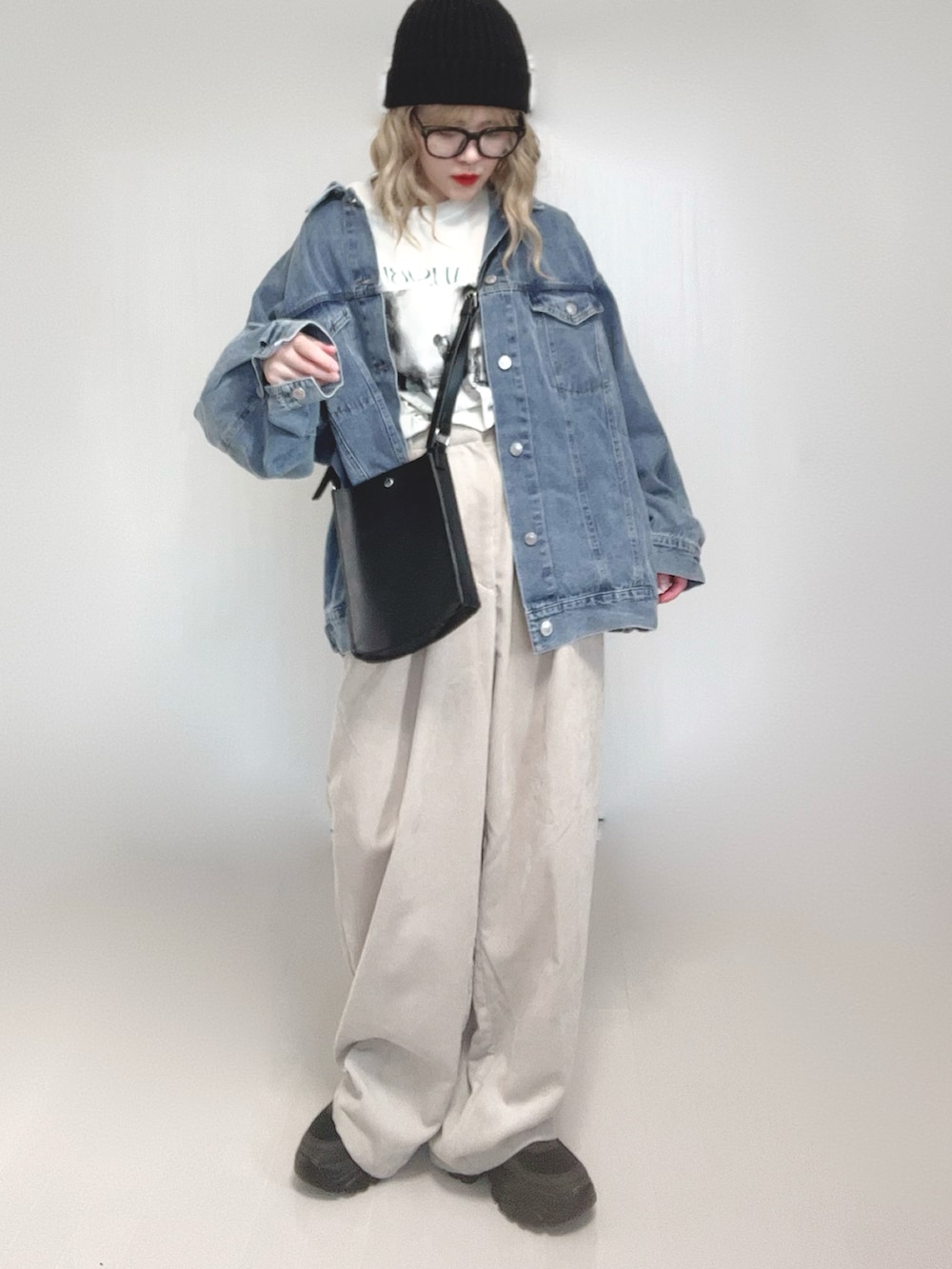 ブルー系のデニムジャケット、ホワイト系のTシャツ/カットソー、ブラック系のショルダーバッグを着用したレディースの春コーディネートの5枚目の写真