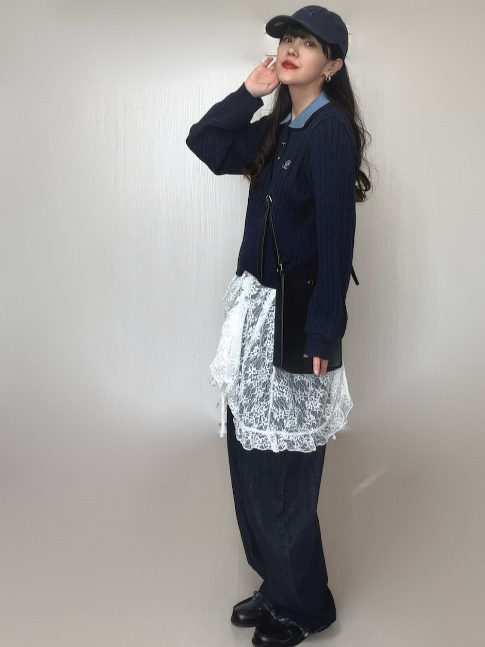 ブルー系のニット/セーター、ホワイト系のワンピース、ブラック系のデニムパンツを着用したレディースの冬コーディネートの2枚目の写真