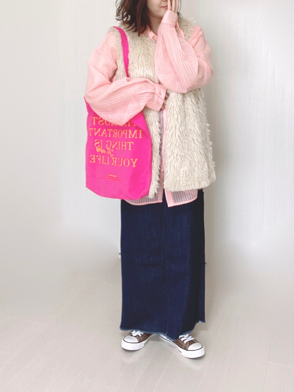 ホワイト系のベスト、ピンク系のシャツ/ブラウス、ブルー系のデニムスカートを着用したレディースの秋コーディネートの3枚目の写真