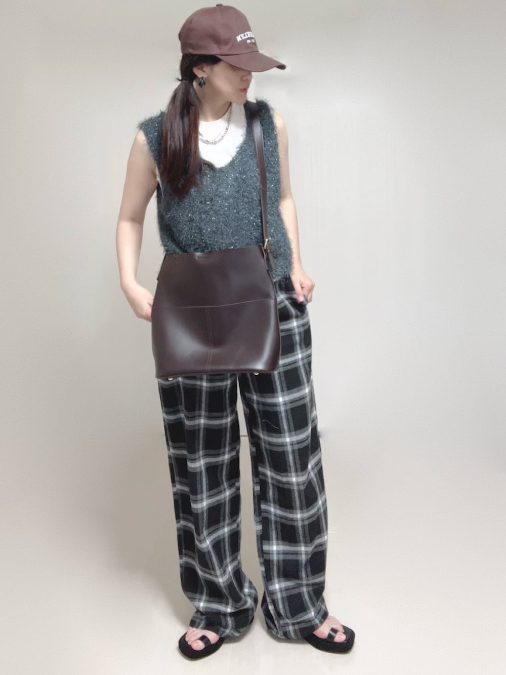 グレー系のベスト、ブラック系のサンダルを着用したレディースの夏コーディネートの2枚目の写真