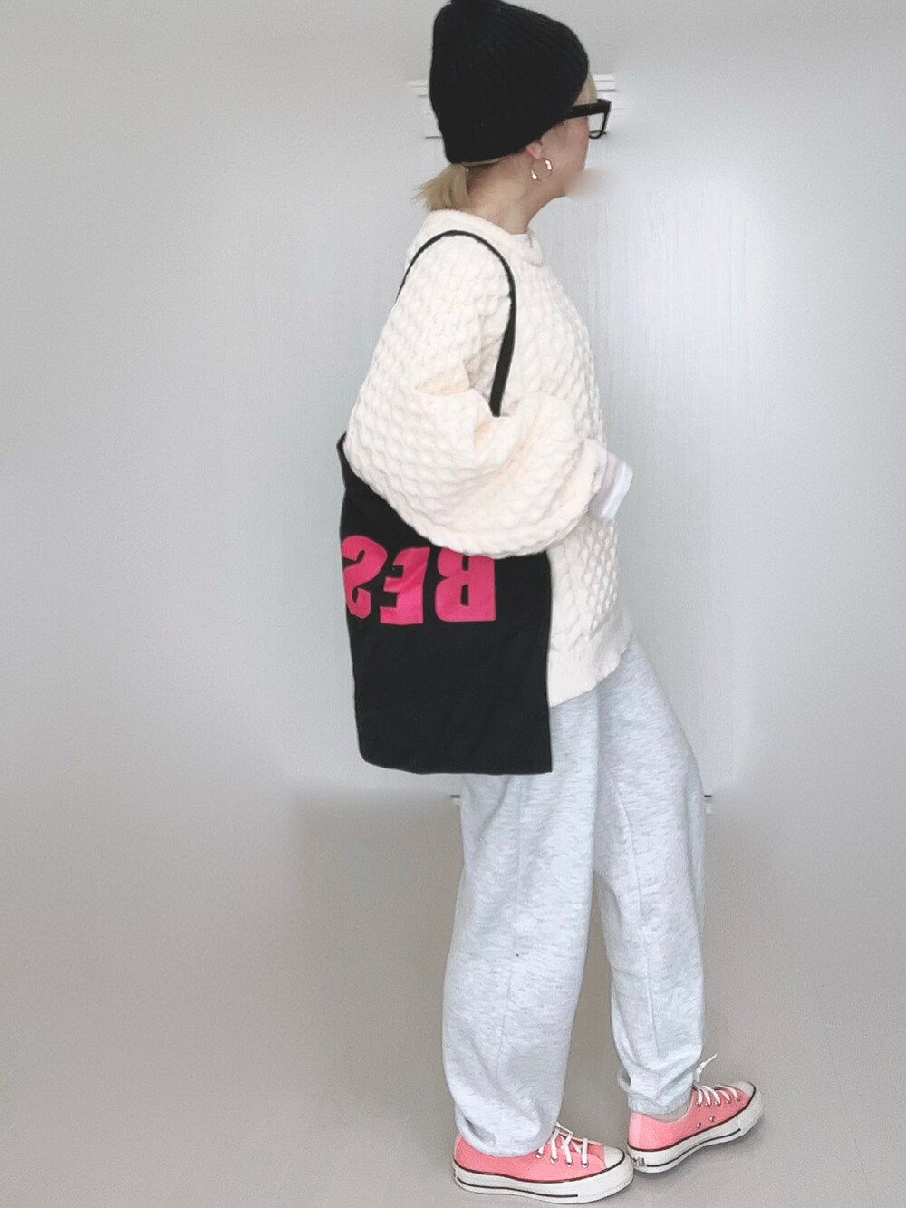 ホワイト系のニット/セーター、ブラック系のトートバッグ、ピンク系のスニーカーを着用したレディースの冬コーディネートの4枚目の写真