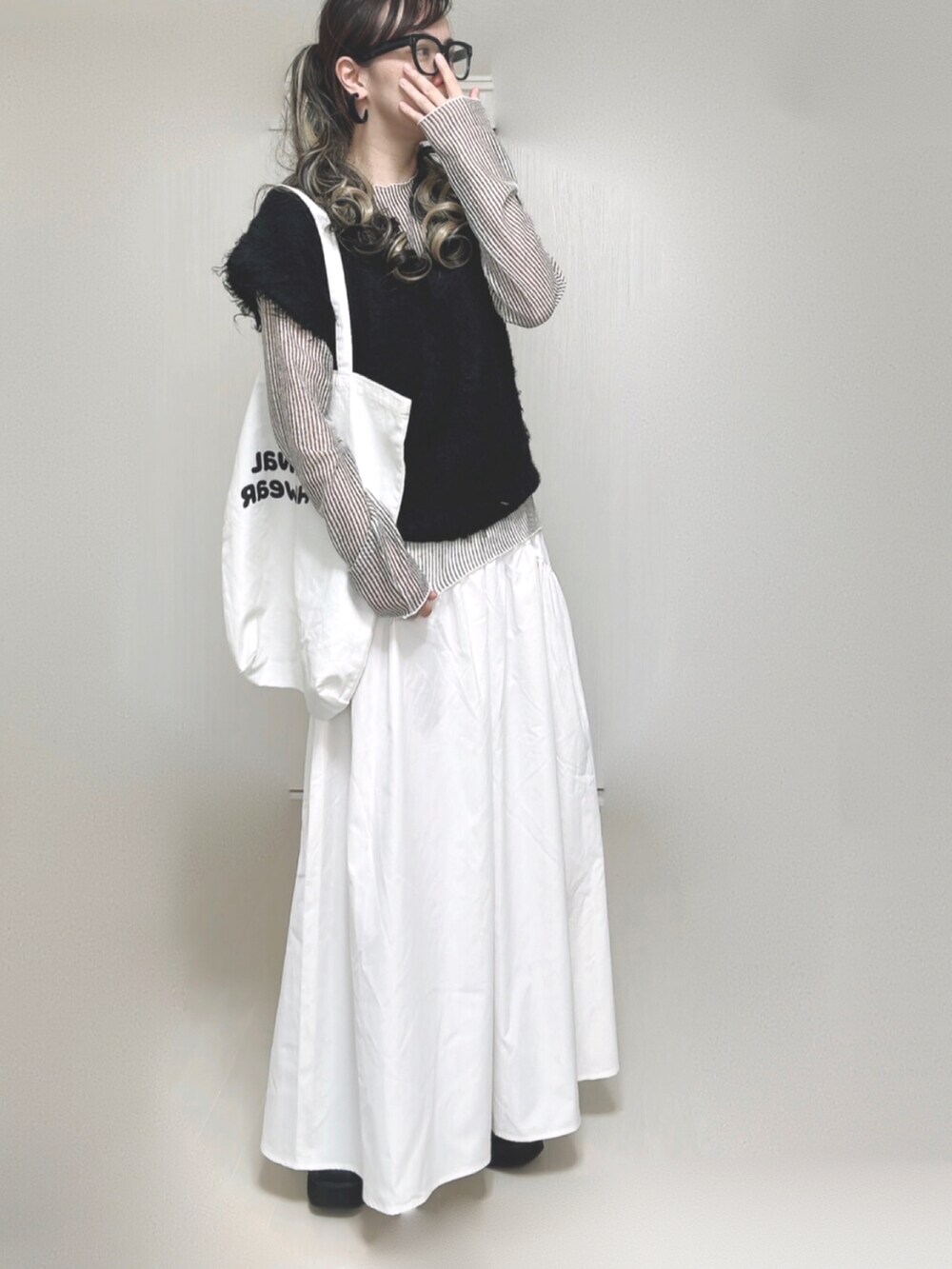 ブラック系のベスト、ホワイト系のシャツ/ブラウス、ホワイト系のトートバッグを着用したレディースの秋コーディネートの4枚目の写真