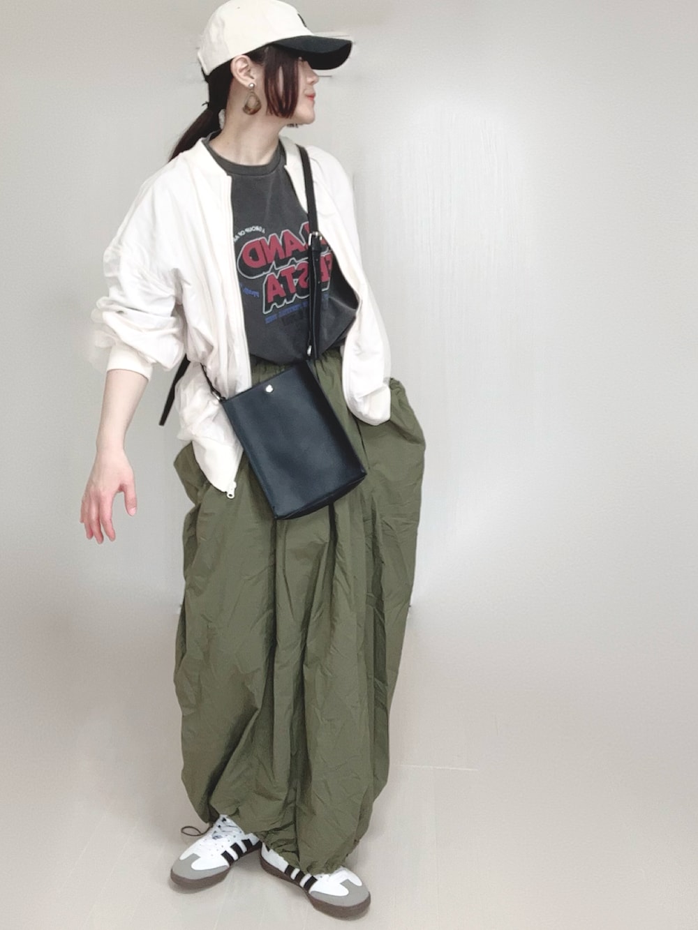 ホワイト系のブルゾン、グレー系のTシャツ/カットソー、ブラック系のショルダーバッグを着用したレディースの春コーディネートの3枚目の写真