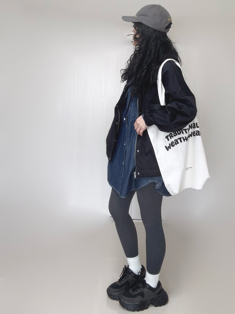ブルー系のシャツ/ブラウス、ブラック系のマウンテンパーカー、ホワイト系のトートバッグを着用したレディースの春コーディネートの2枚目の写真