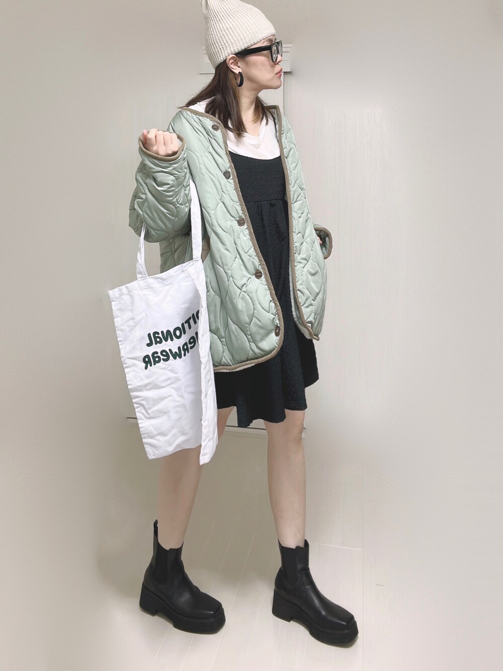 ホワイト系のノーカラージャケット、ホワイト系のTシャツ/カットソー、ブラック系のワンピースを着用したレディースの秋コーディネートの3枚目の写真