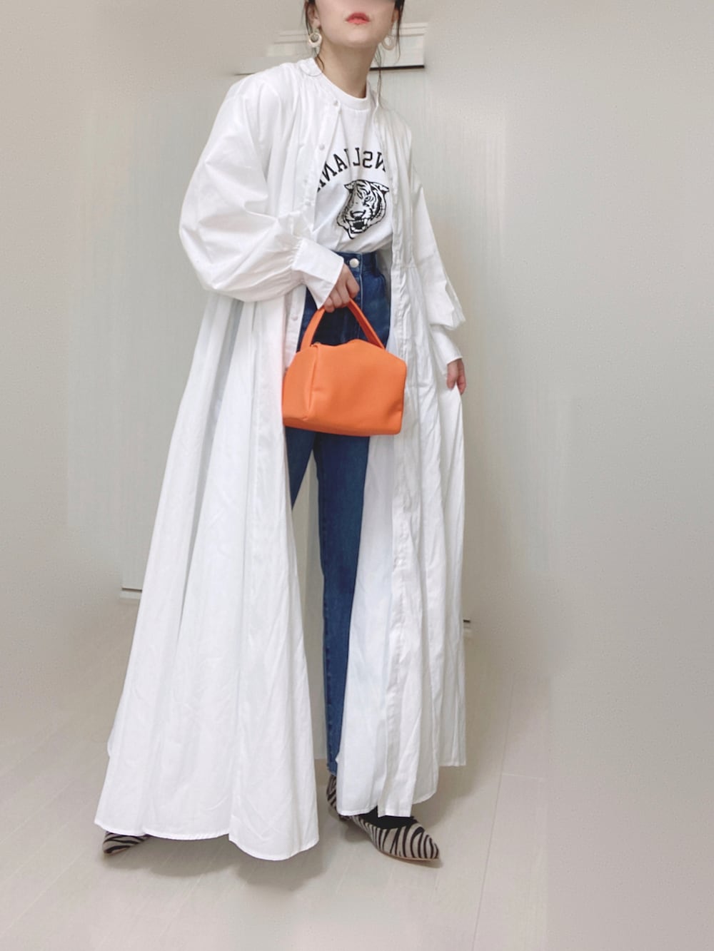 ホワイト系のTシャツ/カットソー、ホワイト系のシャツワンピース、ブルー系のデニムパンツを着用したレディースの春コーディネートの3枚目の写真