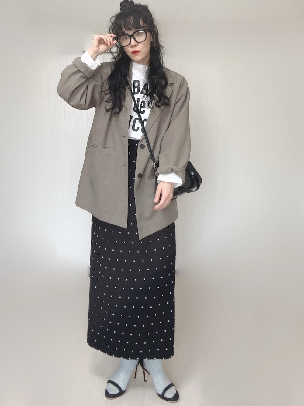 ベージュ系のテーラードジャケット、ブラック系のボストンバッグ、ブラック系のサンダルを着用したレディースの春コーディネートの4枚目の写真