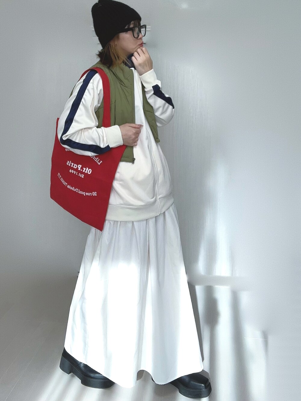 ベージュ系のジャージ、ホワイト系のスカート、ブラック系のブーツを着用したレディースの冬コーディネートの4枚目の写真