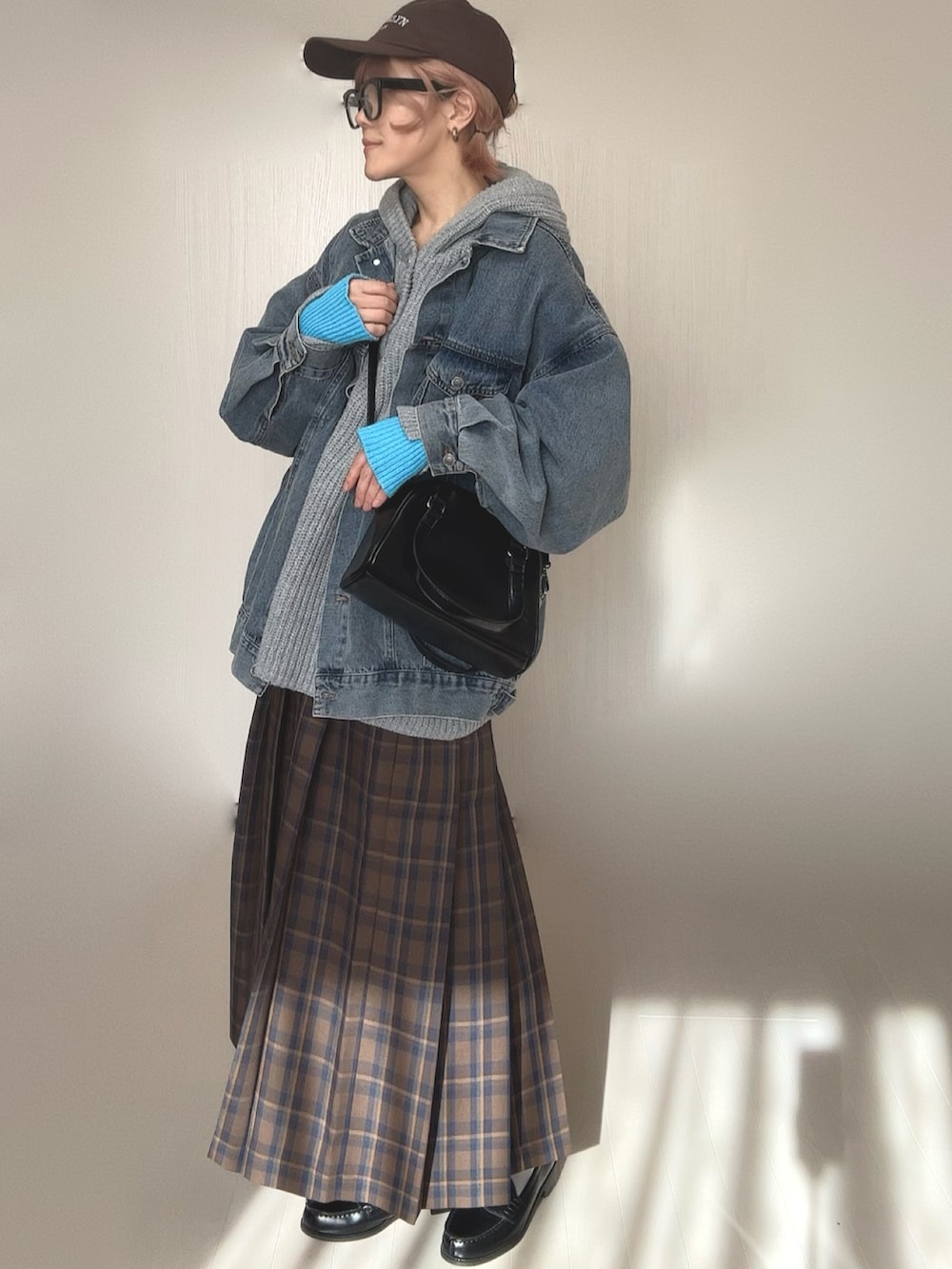 グレー系のニット/セーター、ブルー系のデニムジャケット、ブラウン系のスカートを着用したレディースの冬コーディネートの5枚目の写真