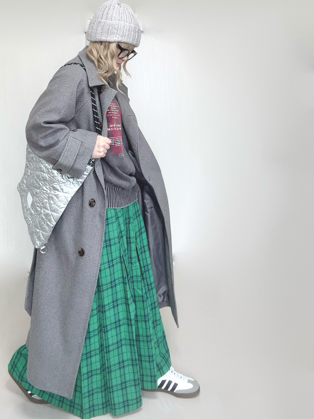 ブラック系のニット/セーター、グレー系のステンカラーコート、シルバー系のトートバッグを着用したレディースの春コーディネートの3枚目の写真