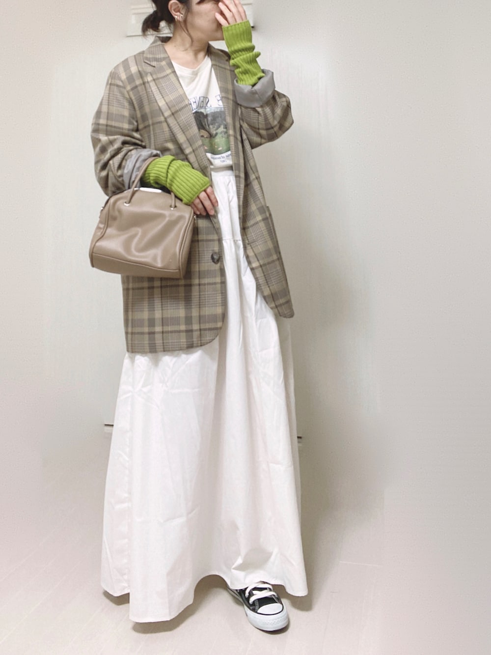 ホワイト系のスカート、ホワイト系のTシャツ/カットソー、ベージュ系のテーラードジャケットを着用したレディースの秋コーディネートの2枚目の写真