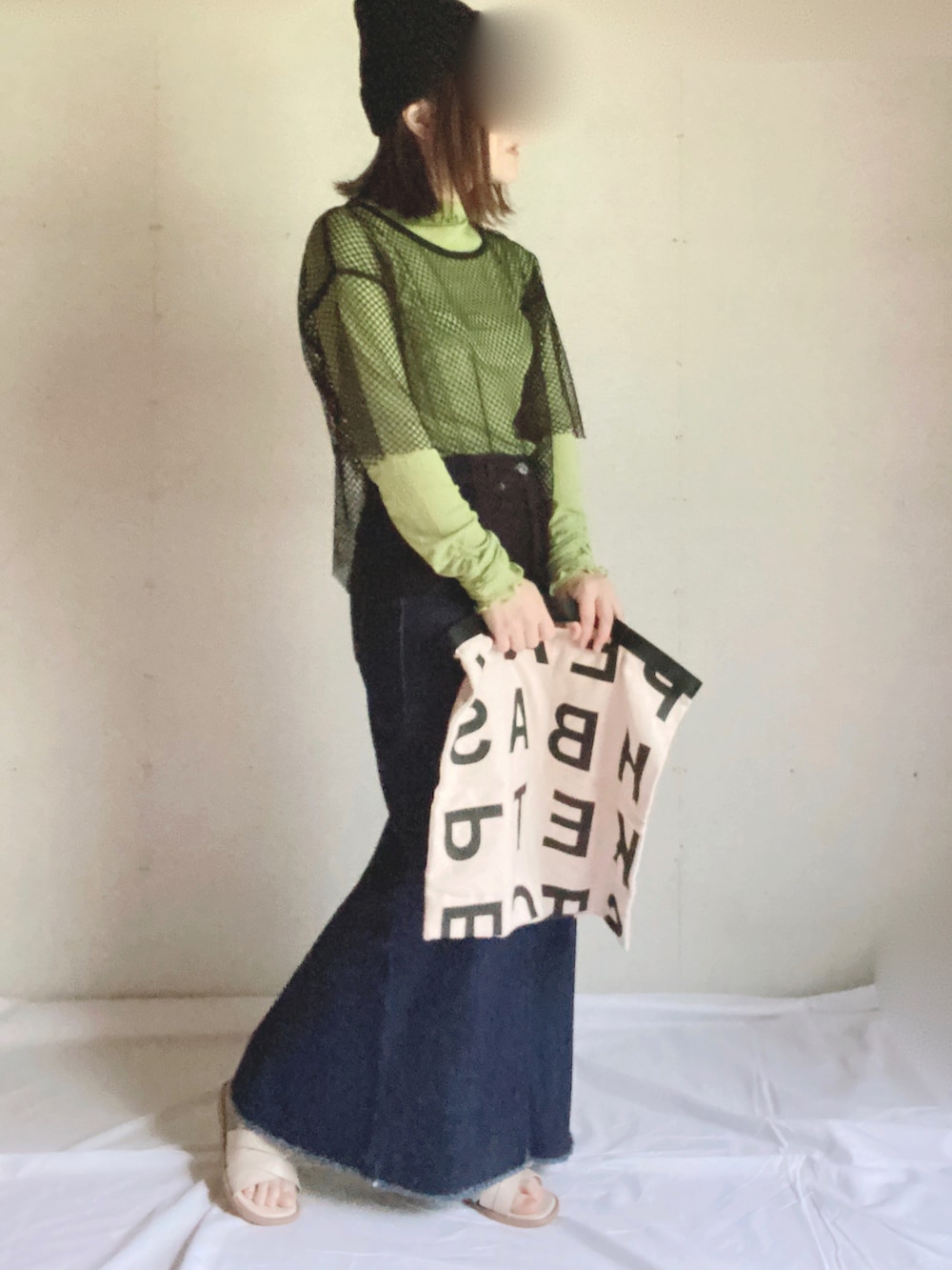 ブルー系のデニムスカート、ホワイト系のサンダル、グリーン系のTシャツ/カットソーを着用したレディースの秋コーディネートの3枚目の写真