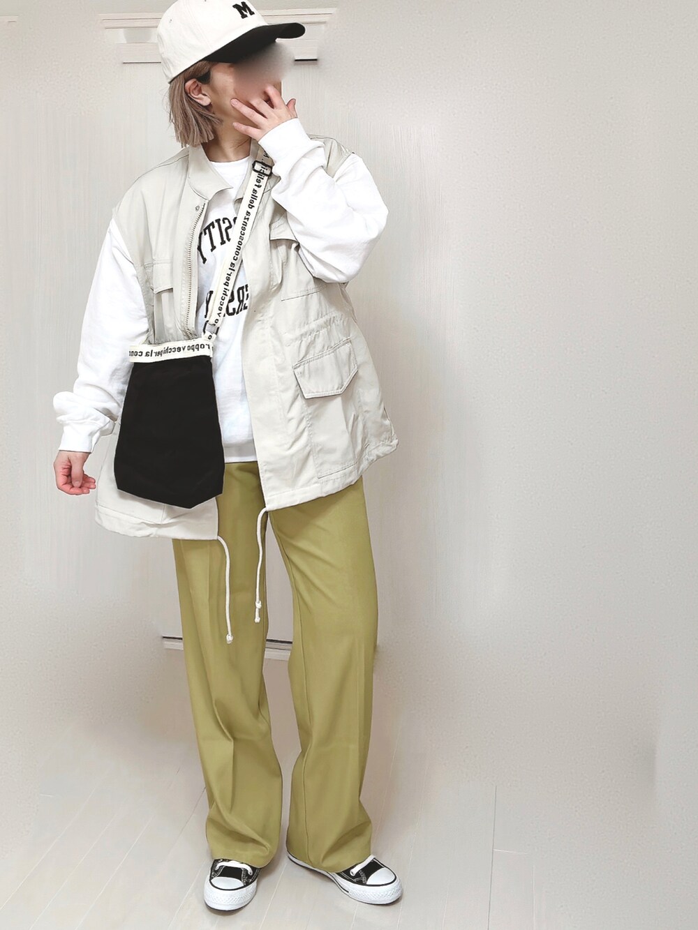 グリーン系のスラックス、ホワイト系のベスト、ホワイト系のスウェットを着用したレディースの春コーディネートの4枚目の写真