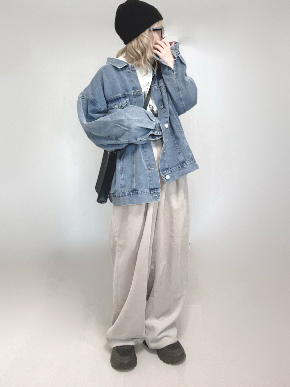 ブルー系のデニムジャケット、ホワイト系のTシャツ/カットソー、ブラック系のショルダーバッグを着用したレディースの春コーディネートの2枚目の写真