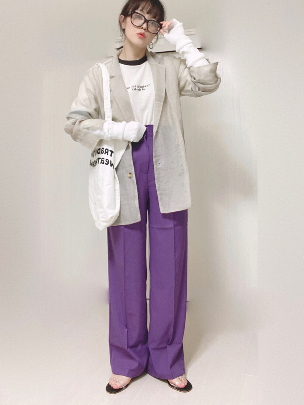 パープル系のスラックス、グレー系のテーラードジャケット、ホワイト系のトートバッグを着用したレディースの秋コーディネートの3枚目の写真
