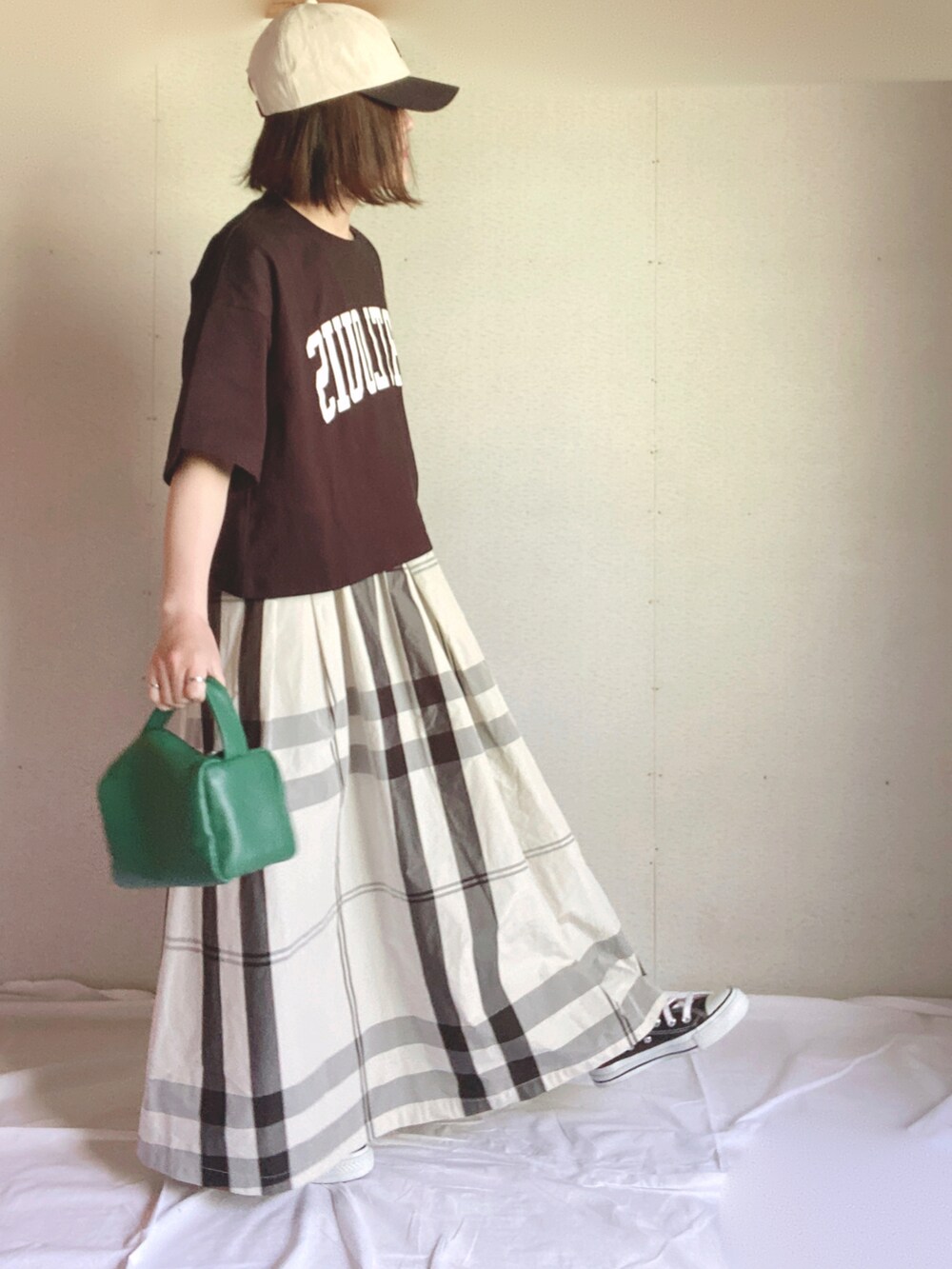 ホワイト系のスカート、ブラック系のTシャツ/カットソー、グリーン系のハンドバッグを着用したレディースの夏コーディネートの4枚目の写真