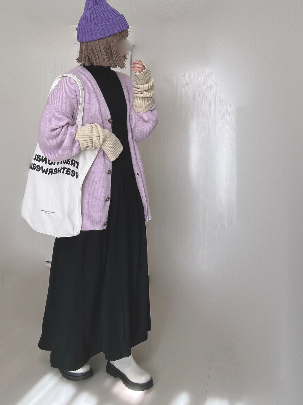 パープル系のカーディガン/ボレロ、ホワイト系のトートバッグ、ブラック系のシャツワンピースを着用したレディースの冬コーディネートの3枚目の写真
