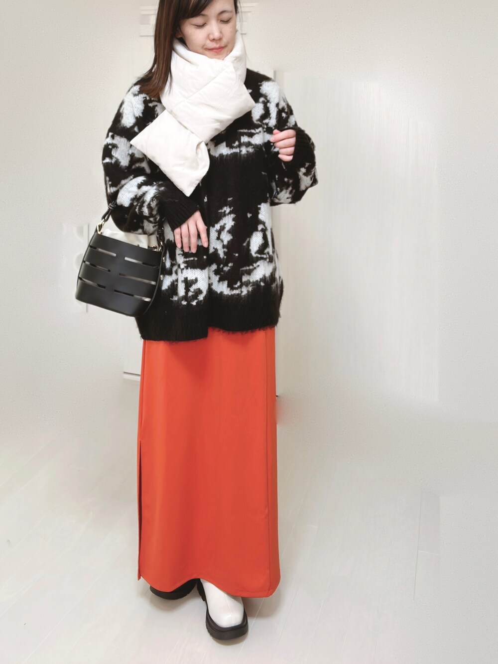 グレー系のノーカラージャケット、ホワイト系のダウンジャケット/コート、ブラック系のニット/セーターを着用したレディースの冬コーディネートの3枚目の写真