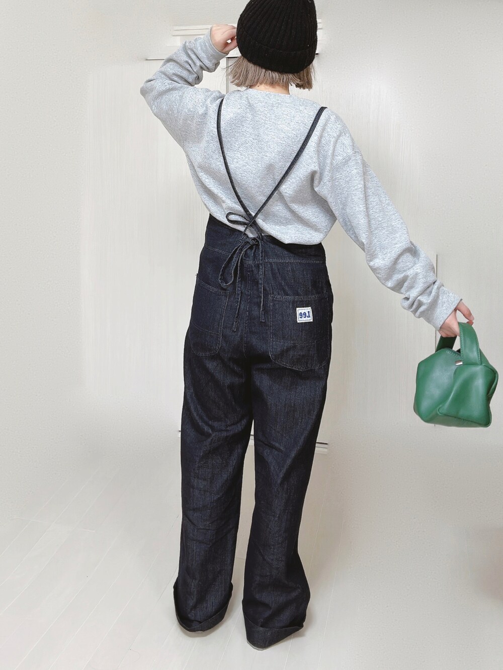 ブルー系のサロペット/オーバーオール、グレー系のスウェット、グリーン系のハンドバッグを着用したレディースの春コーディネートの5枚目の写真