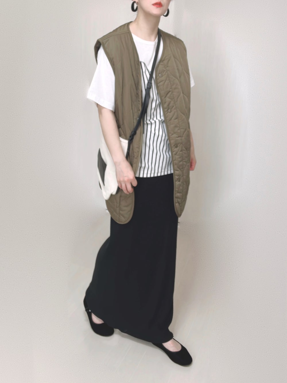 ホワイト系のTシャツ/カットソー、ホワイト系のショルダーバッグ、ブラック系のスカートを着用したレディースの夏コーディネートの4枚目の写真