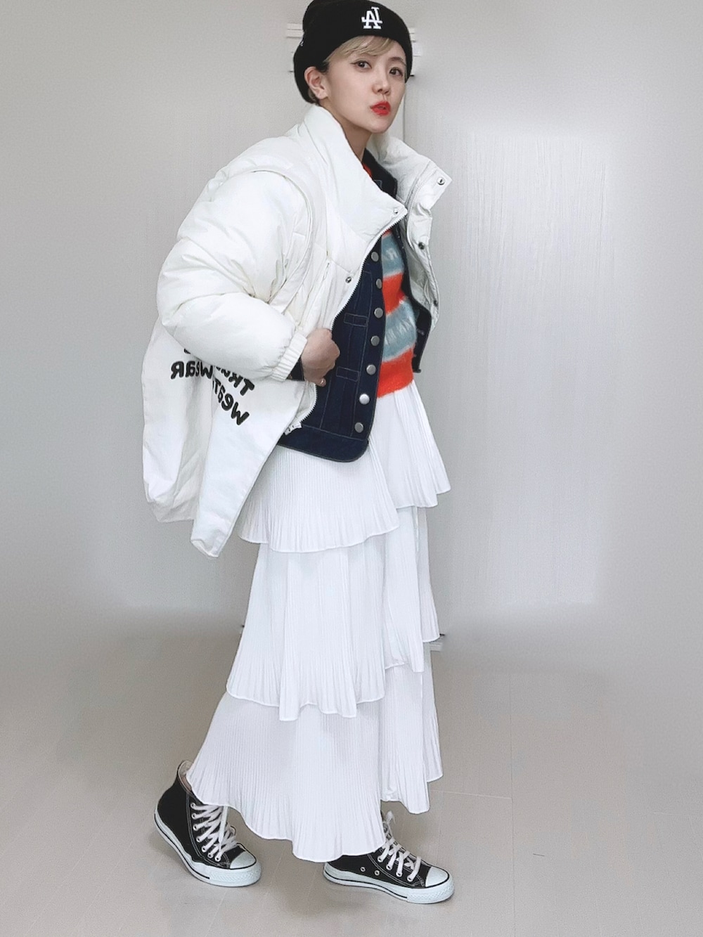 ホワイト系のダウンジャケット/コート、ブルー系のデニムジャケット、オレンジ系のニット/セーターを着用したレディースの冬コーディネートの5枚目の写真