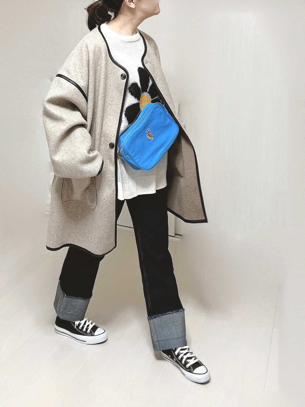 ブルー系のショルダーバッグ、ホワイト系のニット/セーター、ベージュ系のその他アウターを着用したレディースの冬コーディネートの3枚目の写真