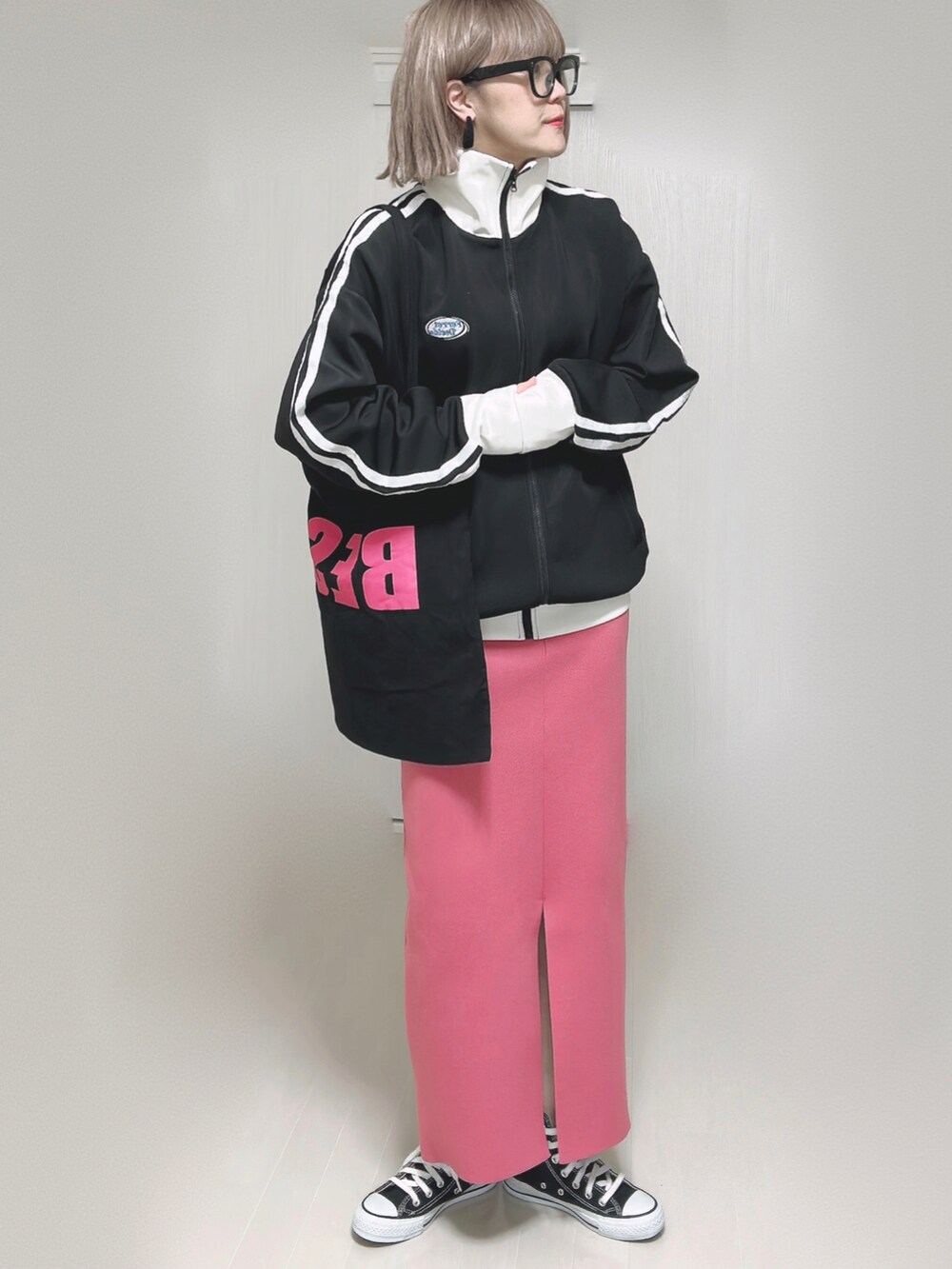 ブラック系のブルゾン、ブラック系のトートバッグ、ピンク系のスカートを着用したレディースの秋コーディネートの5枚目の写真