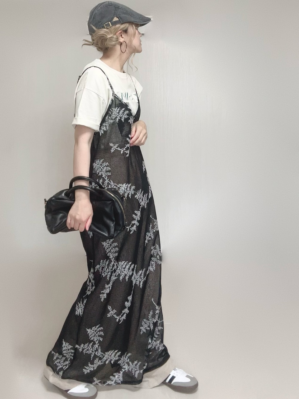 ベージュ系のスラックス、ブラック系のワンピース、ホワイト系のTシャツ/カットソーを着用したレディースの夏コーディネートの3枚目の写真