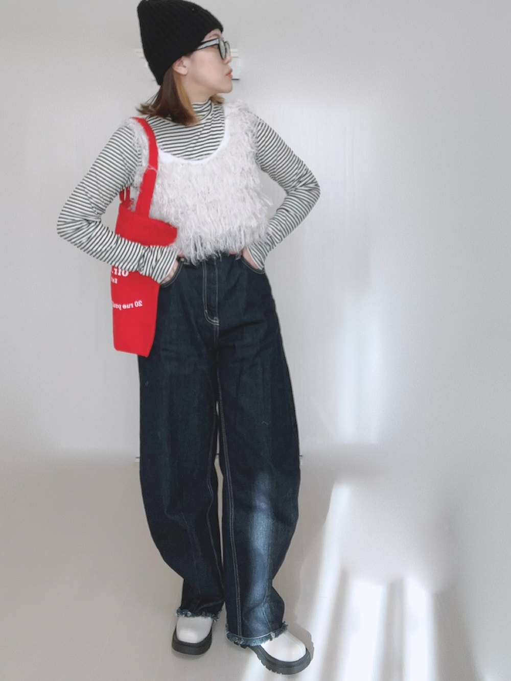 ホワイト系のベスト、ホワイト系のTシャツ/カットソー、ブルー系のデニムパンツを着用したレディースの冬コーディネートの2枚目の写真