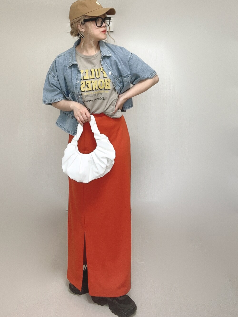 ブルー系のシャツ/ブラウス、オレンジ系のスカート、ブラック系のスニーカーを着用したレディースの夏コーディネートの2枚目の写真