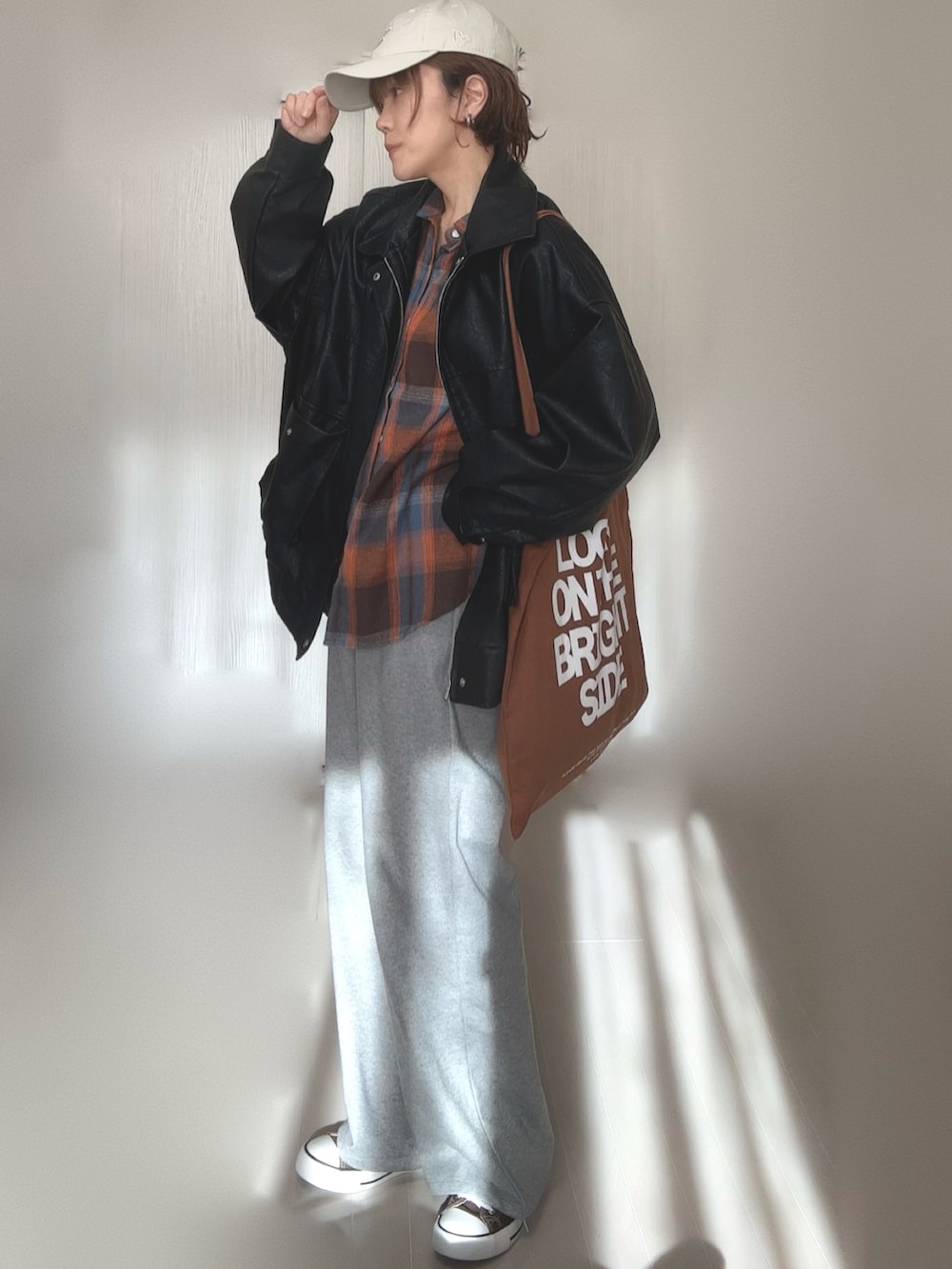 ブラック系のブルゾン、ブラウン系のトートバッグ、ベージュ系のキャップを着用したレディースの冬コーディネートの5枚目の写真