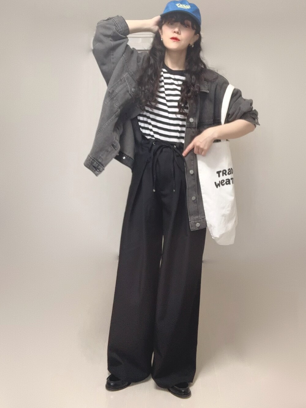 ブラック系のデニムジャケット、ブラック系のスラックス、ホワイト系のTシャツ/カットソーを着用したレディースの春コーディネートの4枚目の写真