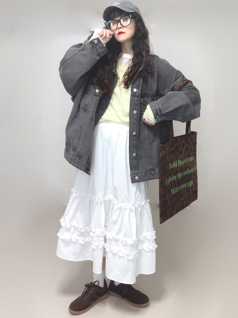 ブラック系のデニムジャケット、ホワイト系のスカート、イエロー系のTシャツ/カットソーを着用したレディースの春コーディネートの5枚目の写真
