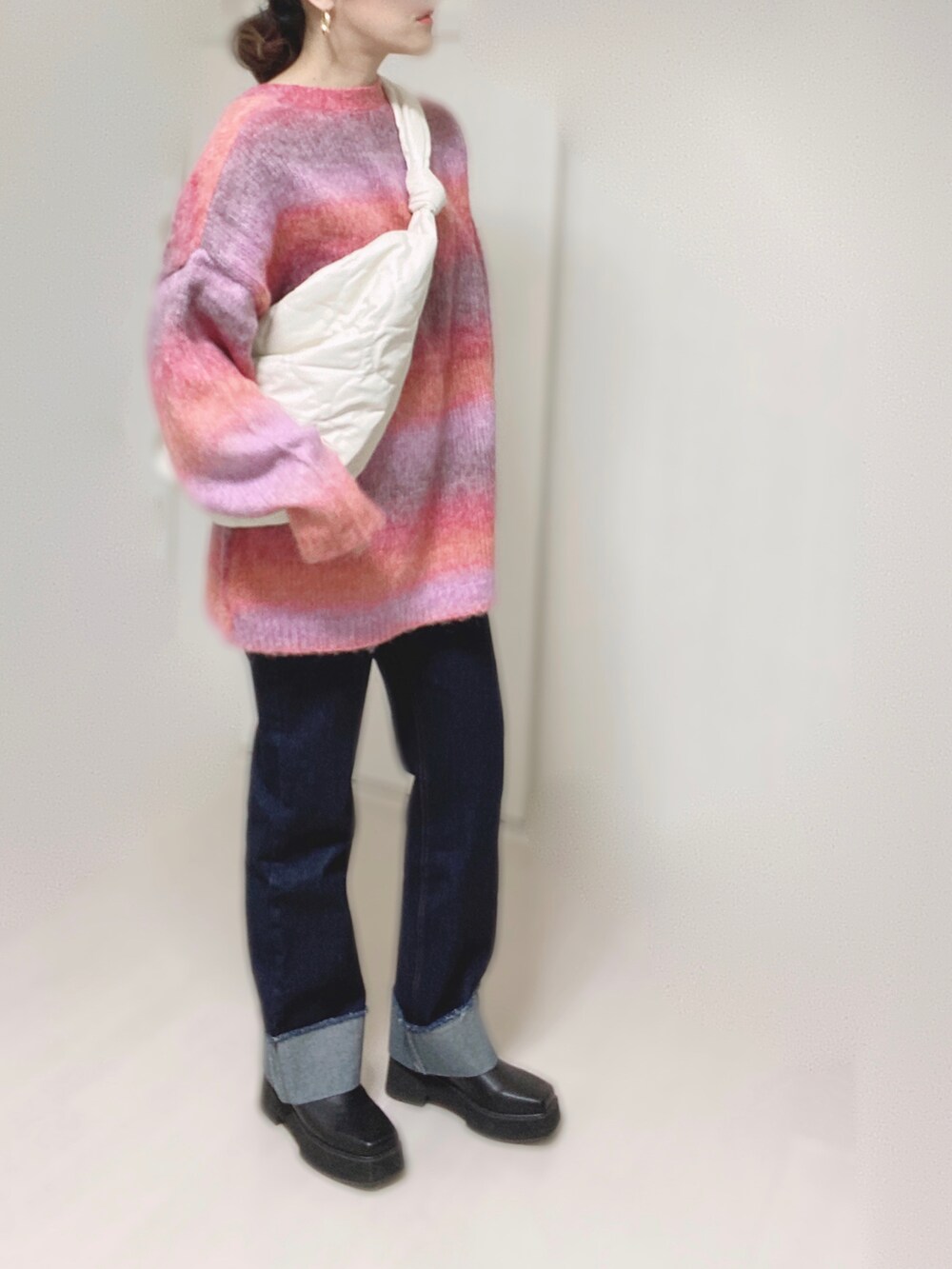 ピンク系のカーディガン/ボレロ、ホワイト系のショルダーバッグ、ブルー系のデニムパンツを着用したレディースの秋コーディネートの3枚目の写真