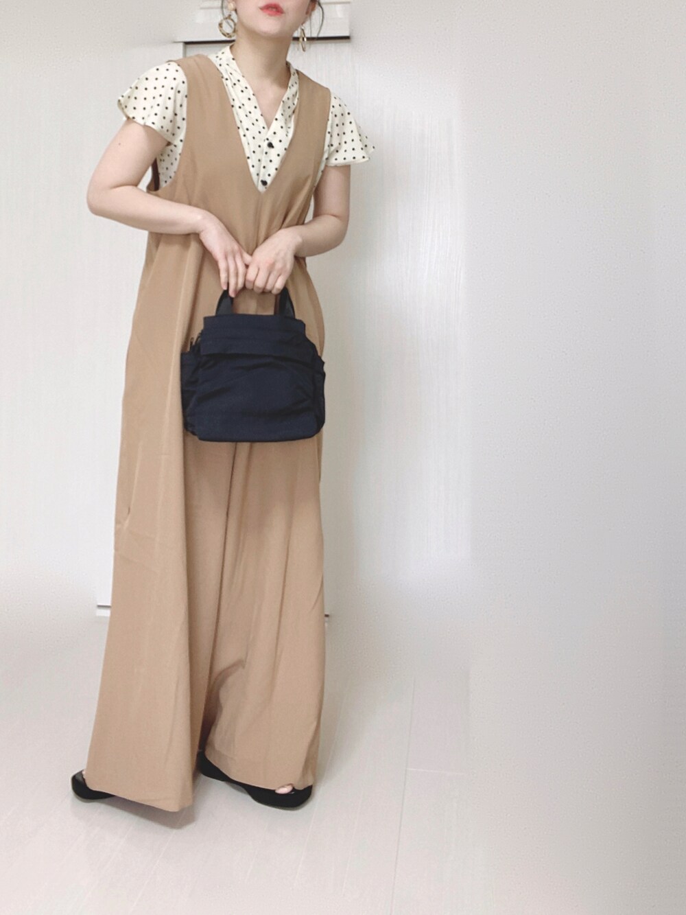 ベージュ系のサロペット/オーバーオール、ブラック系のショルダーバッグ、ブラック系のサンダルを着用したレディースの春コーディネートの2枚目の写真