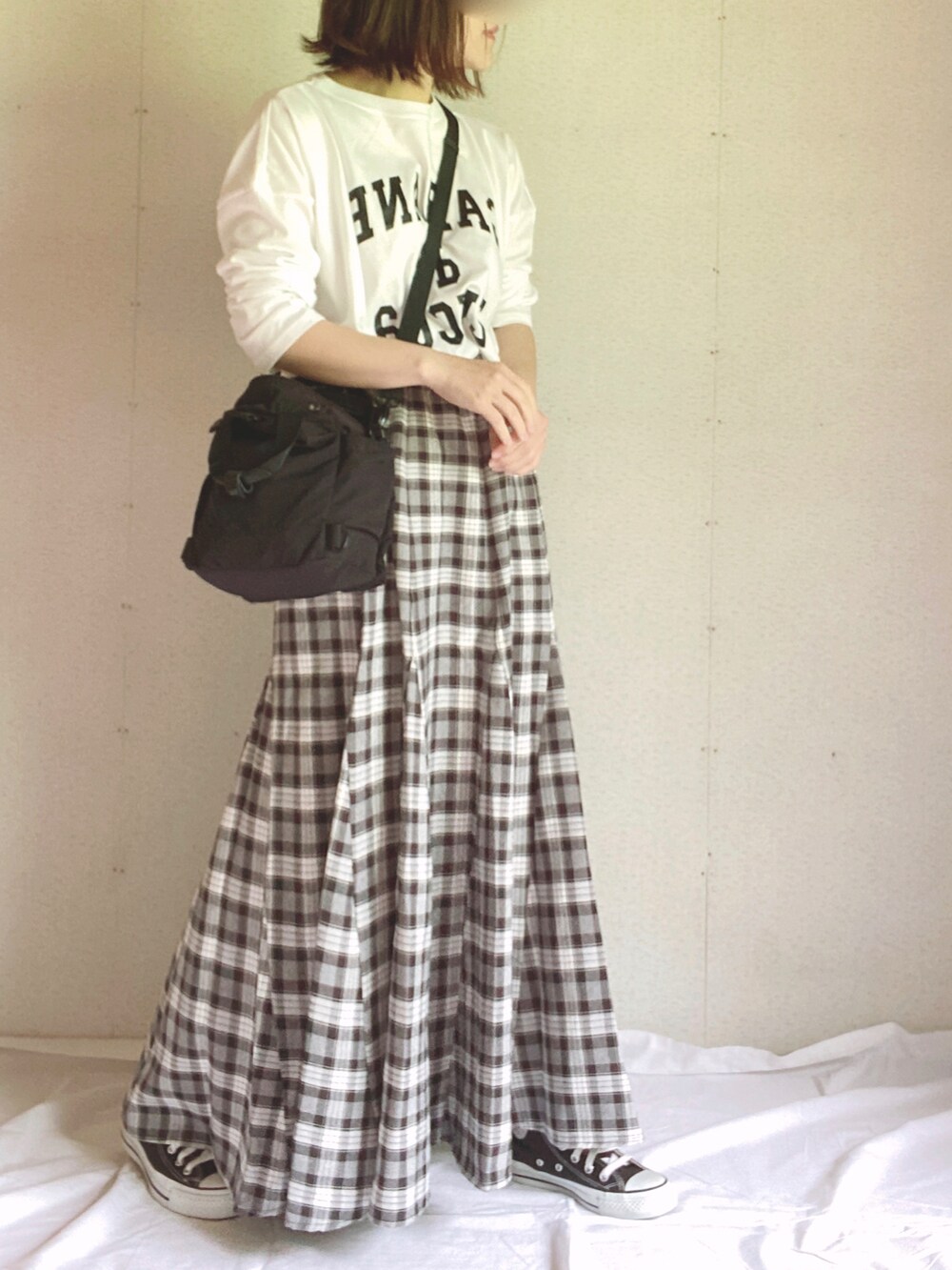 ホワイト系のTシャツ/カットソー、ブラック系のショルダーバッグ、ブラック系のスカートを着用したレディースの夏コーディネートの3枚目の写真