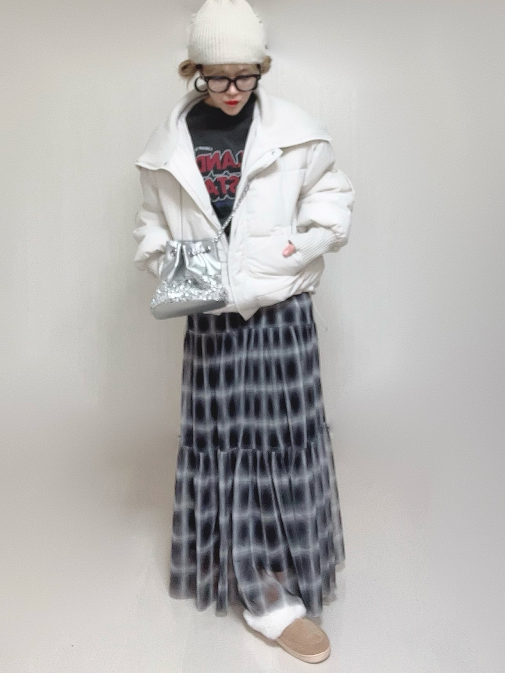 ホワイト系のダウンジャケット/コート、ブラック系のスカート、グレー系のTシャツ/カットソーを着用したレディースの冬コーディネートの5枚目の写真