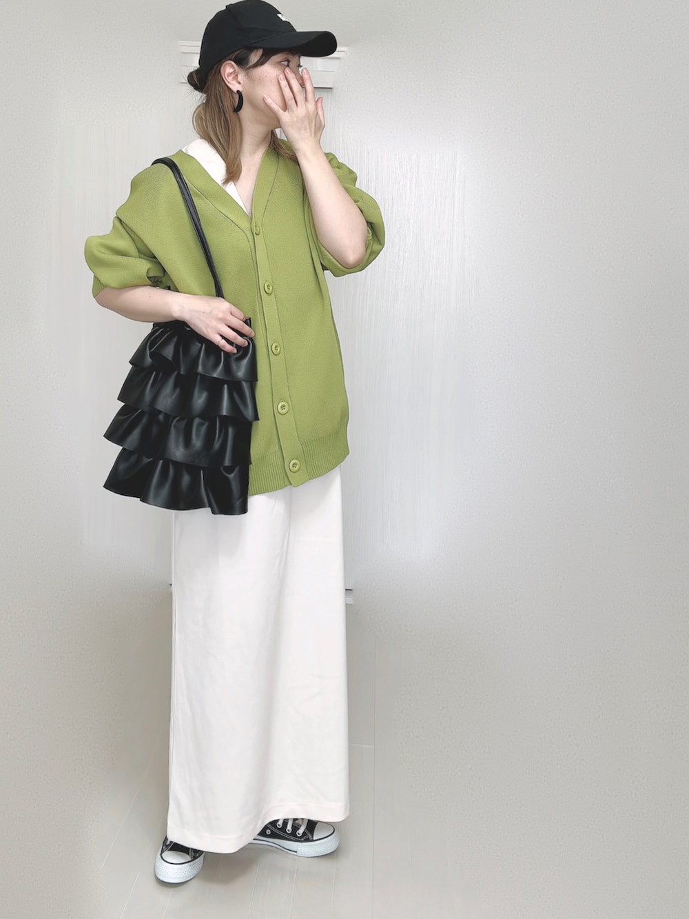 グリーン系のカーディガン/ボレロ、ホワイト系のワンピース、ブラック系のスニーカーを着用したレディースの秋コーディネートの4枚目の写真