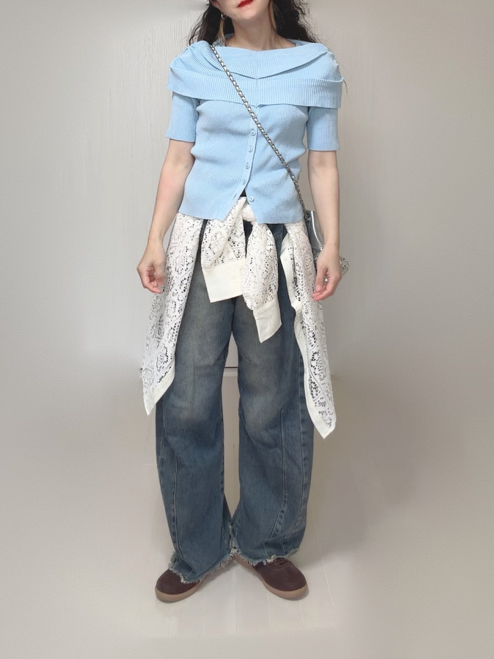 ブルー系のニット/セーター、ホワイト系のシャツ/ブラウス、シルバー系のショルダーバッグを着用したレディースの夏コーディネートの3枚目の写真
