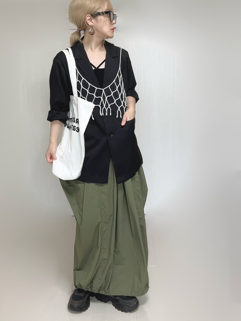 ブラック系のテーラードジャケット、ブラック系のキャミソール、ホワイト系のベストを着用したレディースの夏コーディネートの2枚目の写真