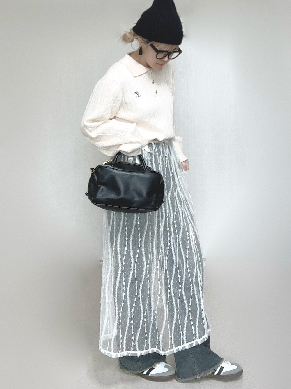 ホワイト系のニット/セーター、ブルー系のデニムパンツ、ホワイト系のスカートを着用したレディースの冬コーディネートの3枚目の写真