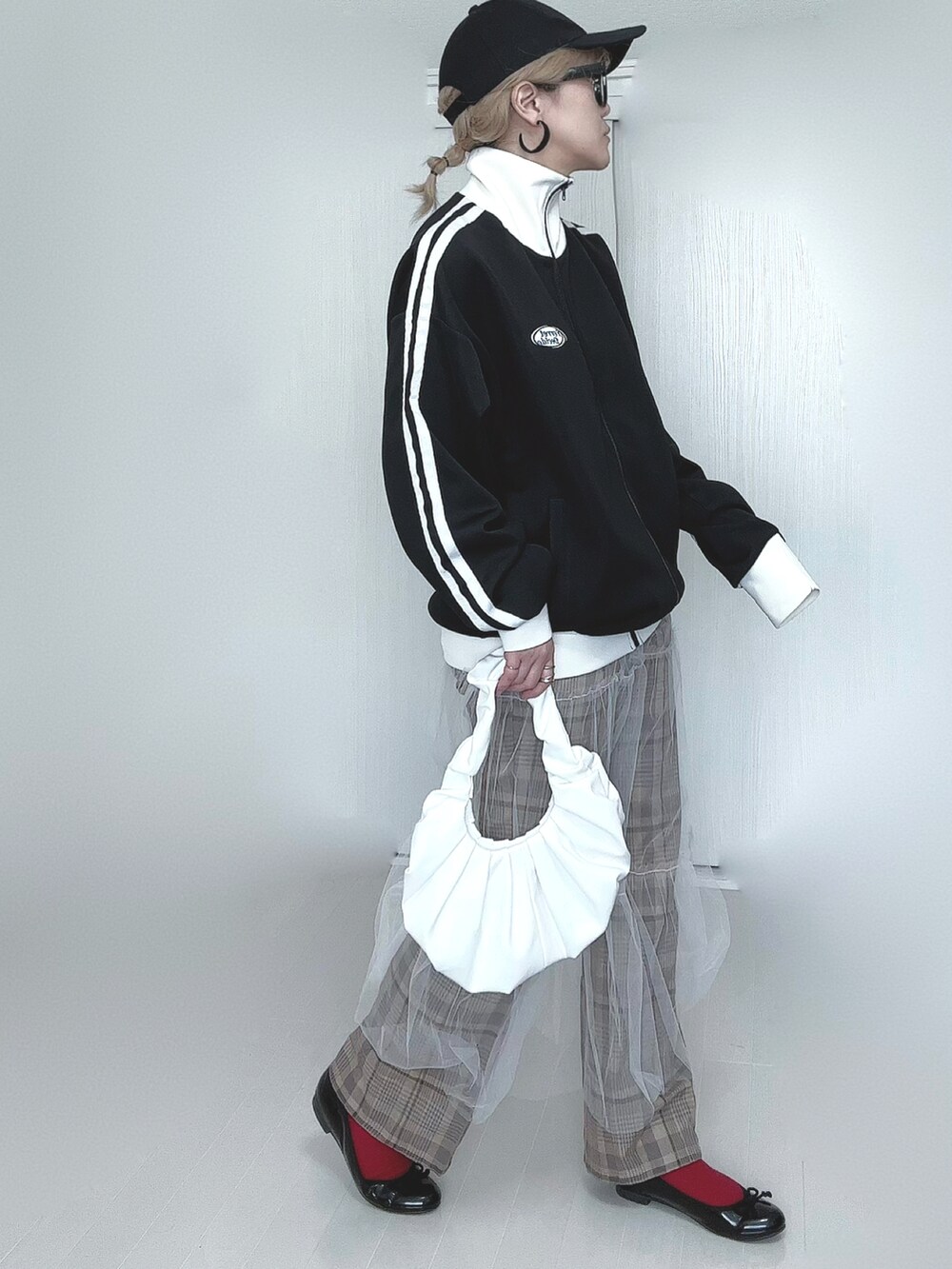 ブラック系のブルゾン、ホワイト系のスカート、ベージュ系のその他パンツを着用したレディースの春コーディネートの3枚目の写真