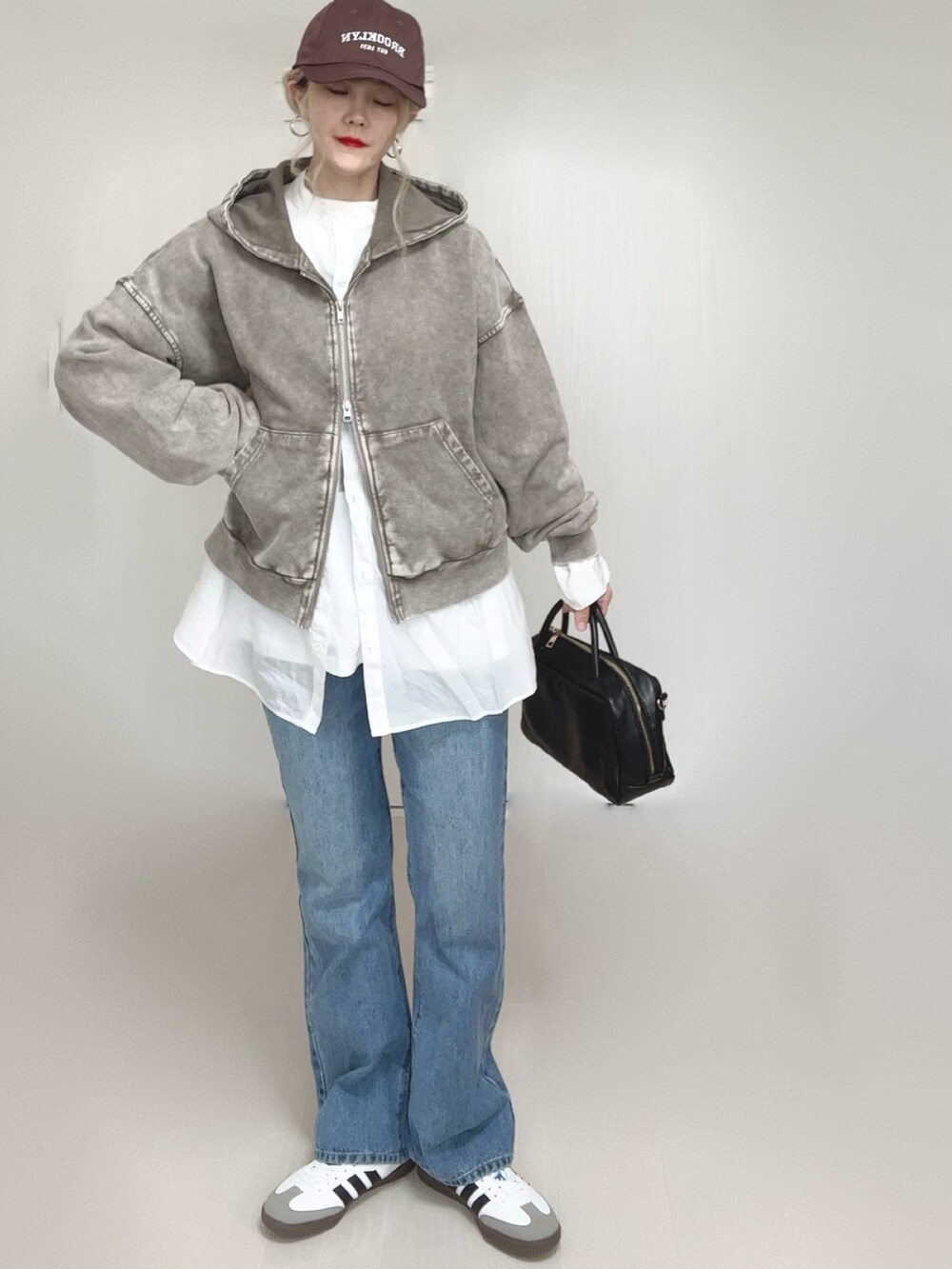 ブルー系のデニムパンツ、グレー系のパーカー、ホワイト系のTシャツ/カットソーを着用したレディースの春コーディネートの3枚目の写真