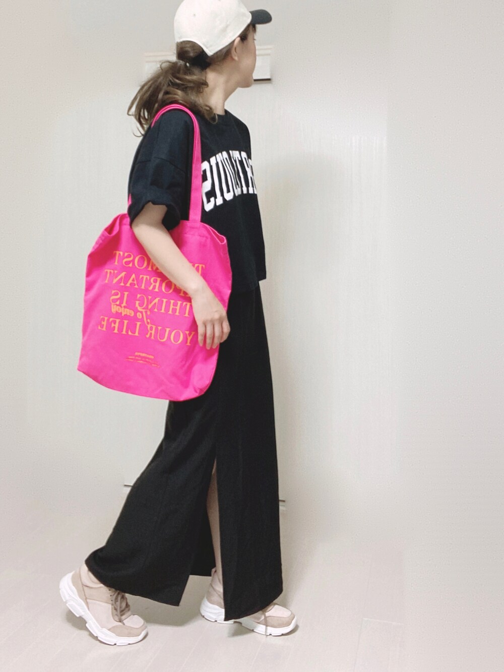 ブラック系のスカート、ピンク系のスニーカー、ブラック系のTシャツ/カットソーを着用したレディースの夏コーディネートの4枚目の写真