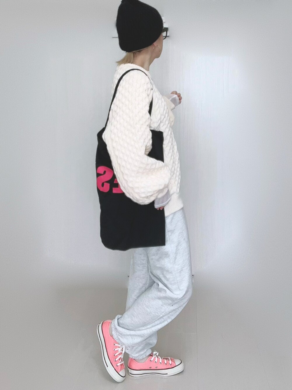ホワイト系のニット/セーター、ブラック系のトートバッグ、ピンク系のスニーカーを着用したレディースの冬コーディネートの5枚目の写真